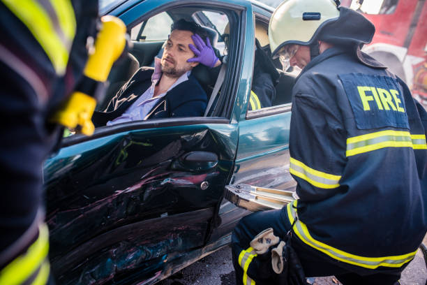 First responders assisting an injured accident victim at a crash scene